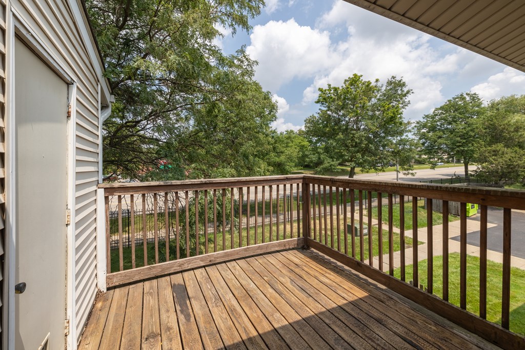 the view from the deck of a house with a yard and trees