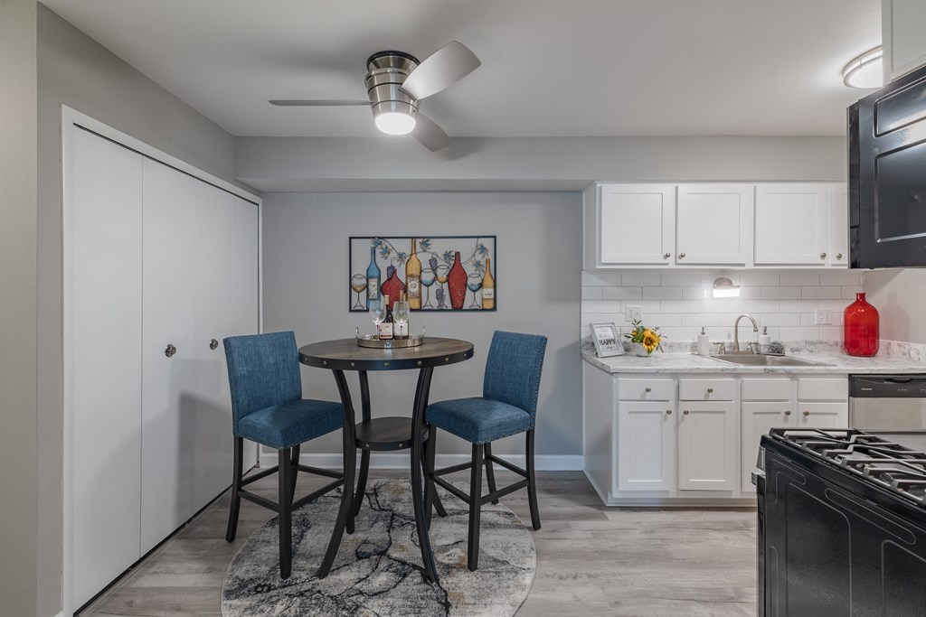 a kitchen and dining area with a round table and two blue chairs