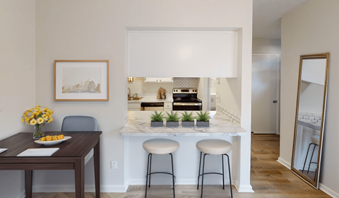 A kitchen with a table and chairs in front of it.