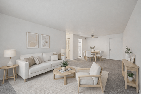 A living room with a white couch, two chairs, and a coffee table.