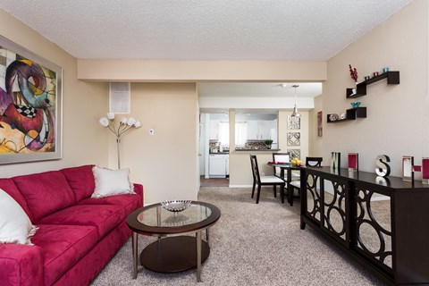A living room with a red couch and a coffee table.