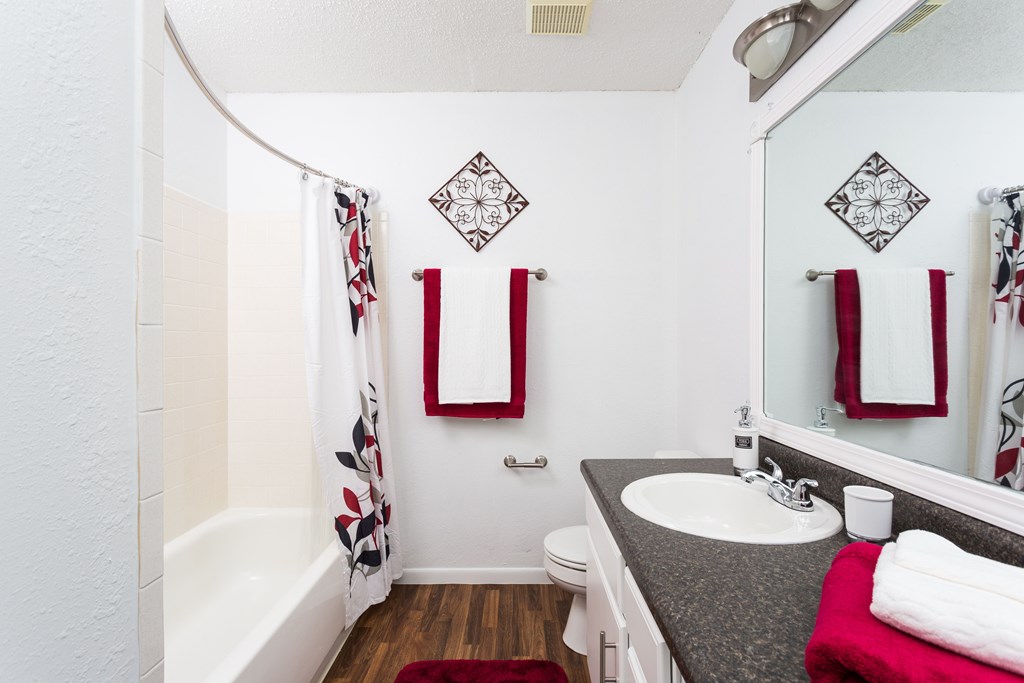 A bathroom with a white tub, sink, and toilet.