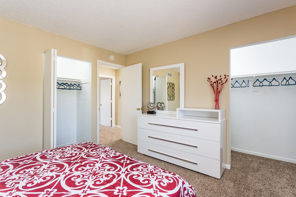 A bedroom with a bed, dresser, and mirror.