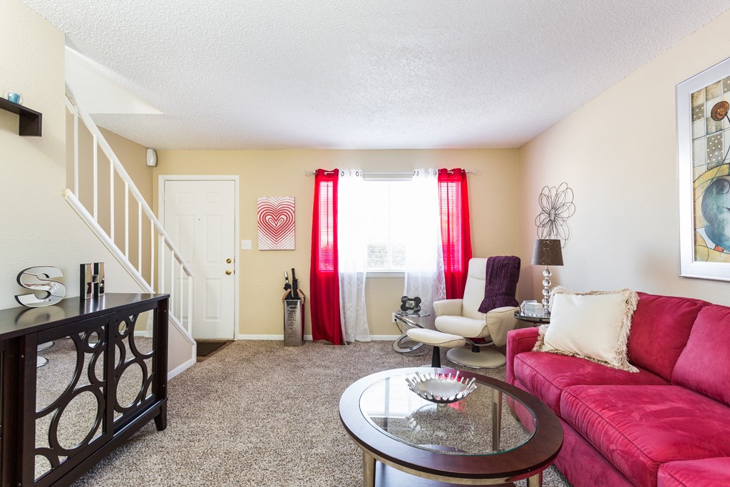A living room with a red couch and a coffee table.