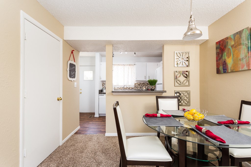 A dining room with a glass table and chairs.