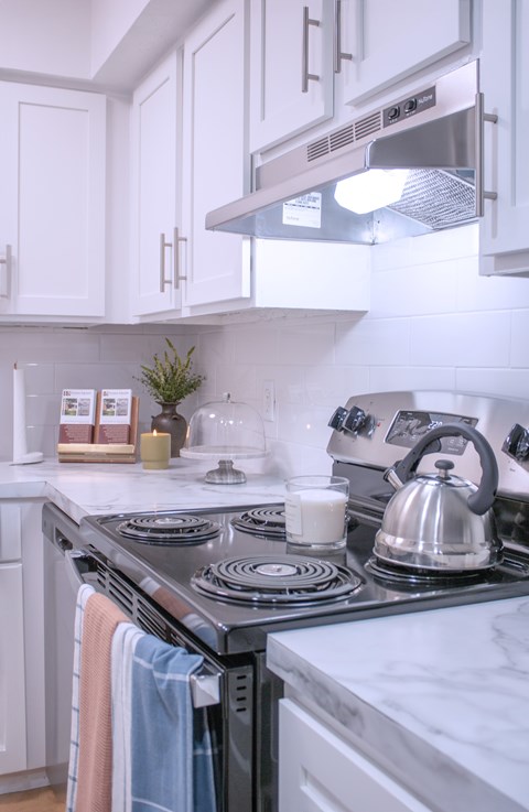 a small kitchen with a stove and a kettle on the stove