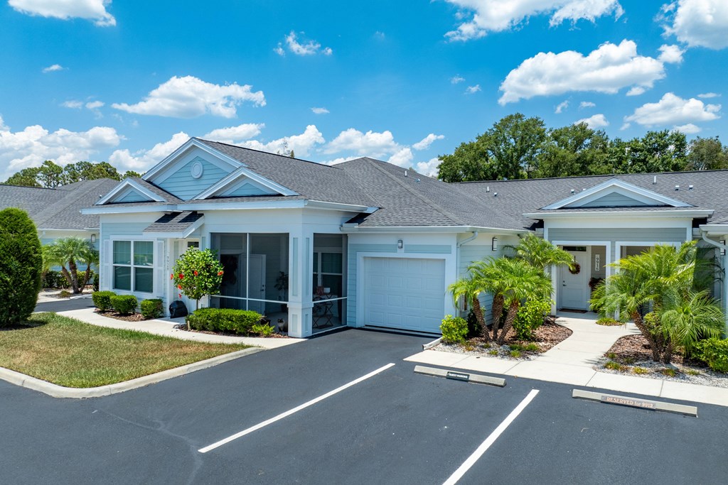 a white house with a driveway and garage doors