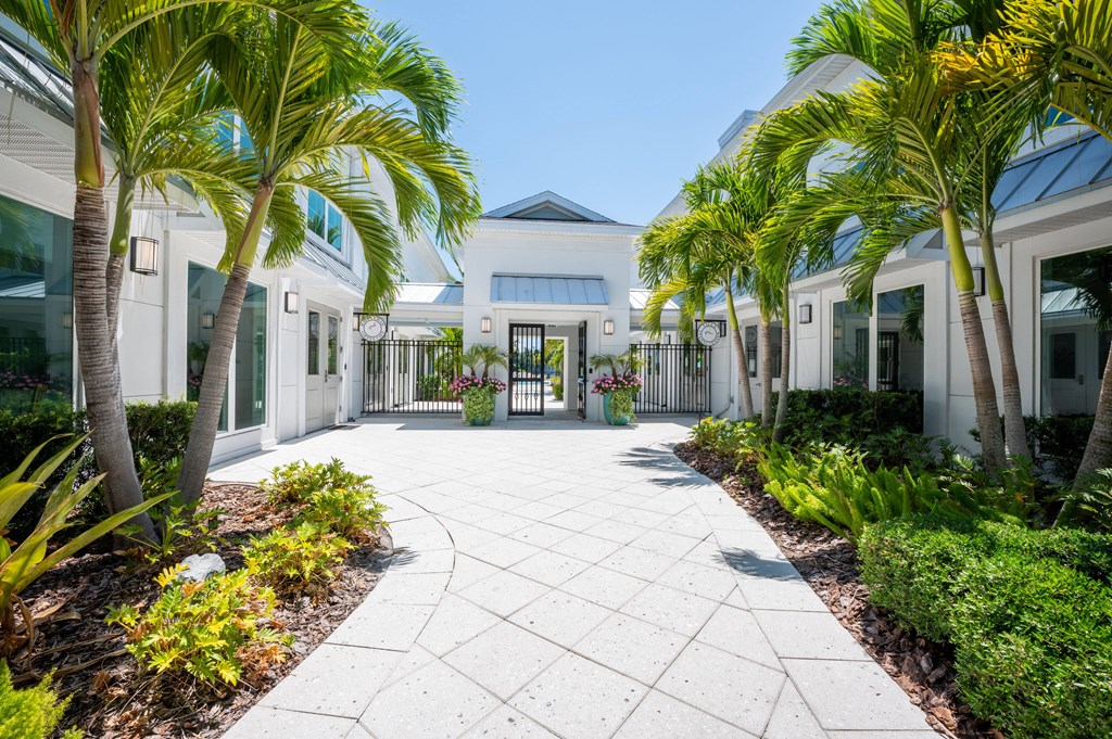 a courtyard with palm trees in front of a house