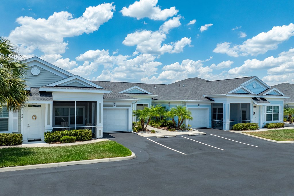 a house with a parking lot and palm trees
