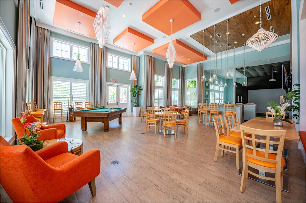 a clubhouse with tables and chairs and a pool table