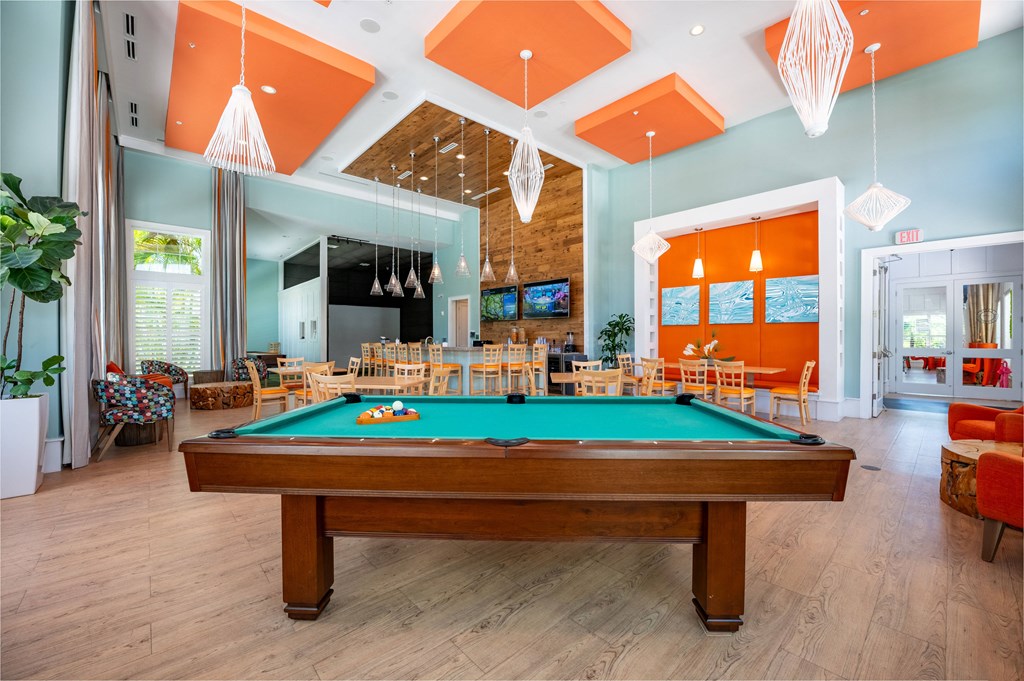 a pool table in the lobby of a house with a dining room