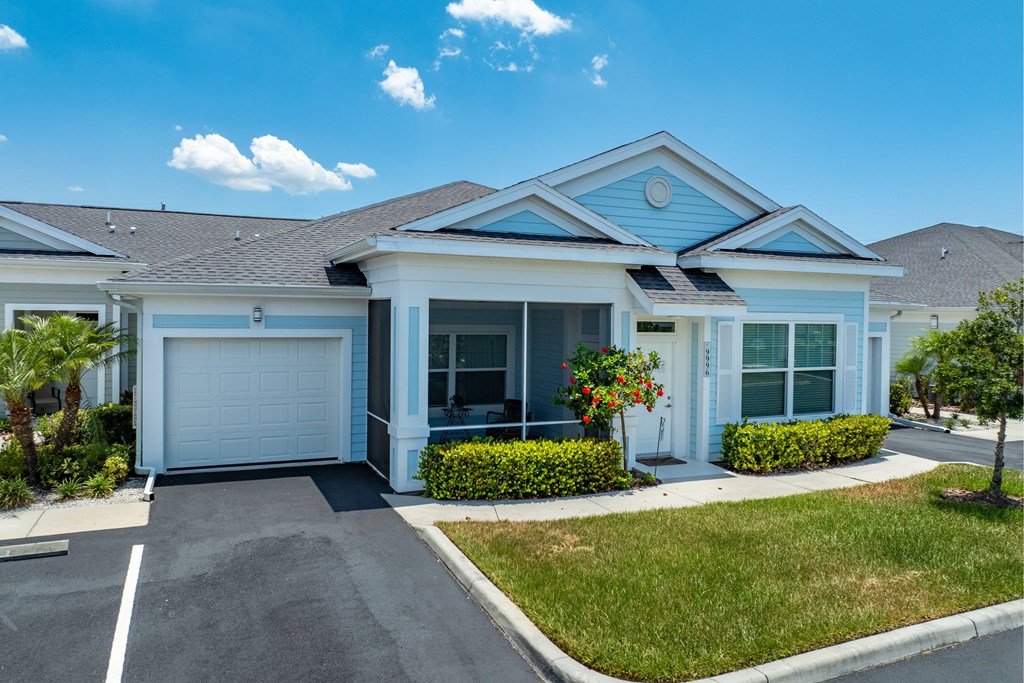 a blue and white house with a garage door and a lawn