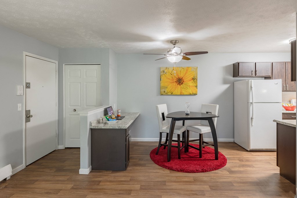 a kitchen and dining area with a small table and a refrigerator