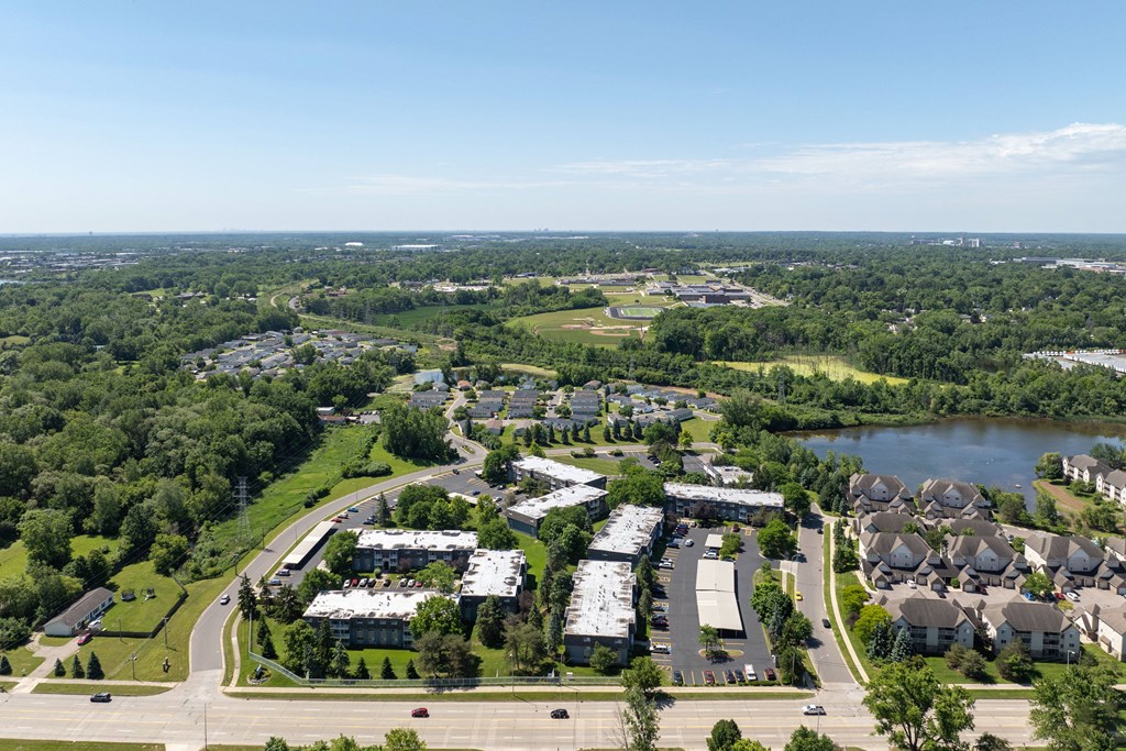 an aerial view of a city with houses and a lake