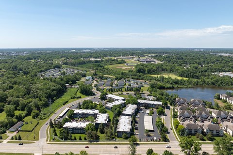 an aerial view of a city with houses and a lake