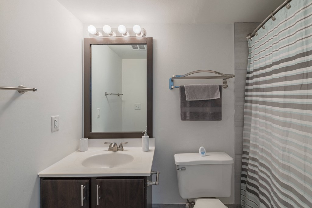 a bathroom with a toilet sink and a mirror