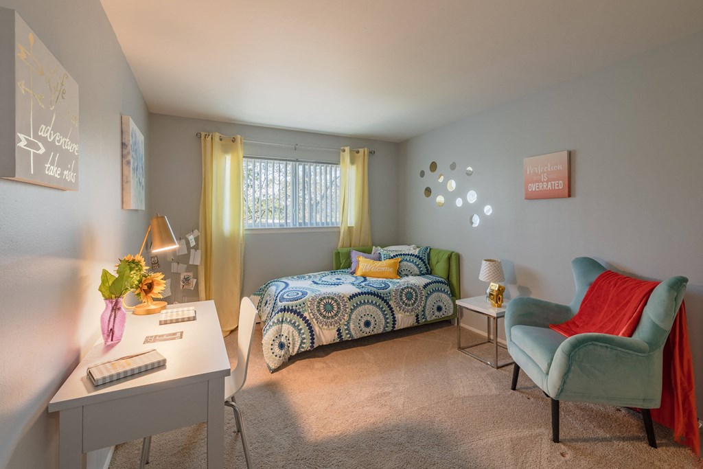 a bedroom with a bed and a desk and a chair