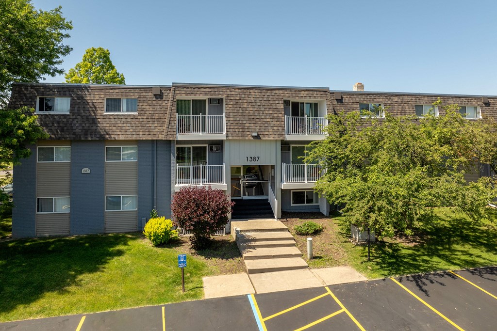 front view of an apartment building with sidewalks and grass