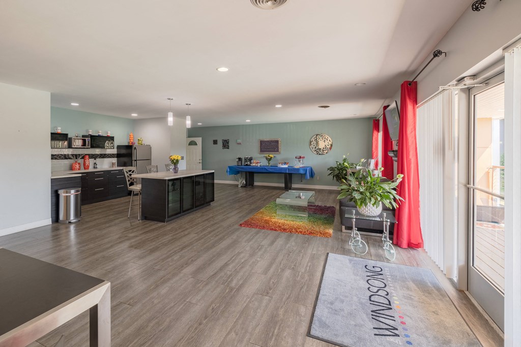 a living room with a ping pong table and a kitchen