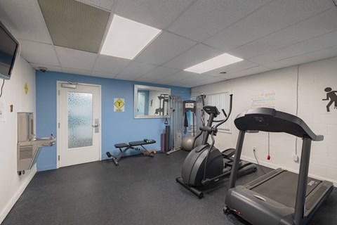 a gym with treadmills and other exercise equipment inside of a building