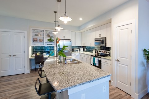 an open kitchen and dining area with a granite counter top