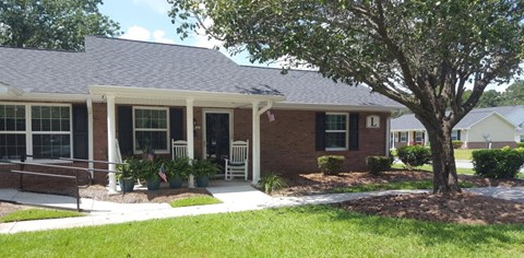 a house with a porch and a tree in front of it