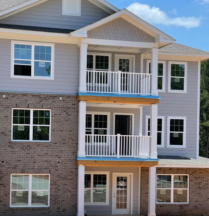 a white house with a balcony and a brick