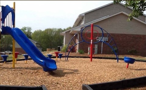 a playground with a blue slide and a red