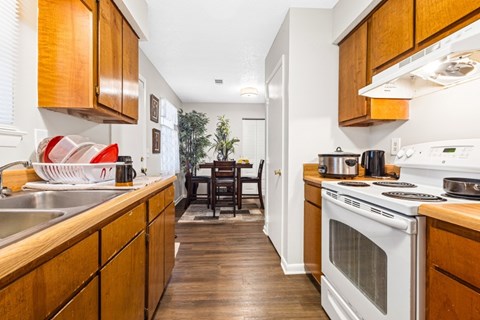 A kitchen with wooden cabinets and a white oven.