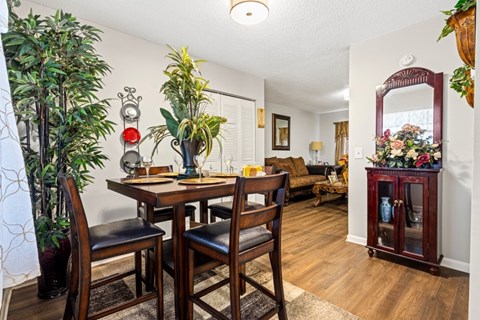 A dining room with a wooden table and chairs.