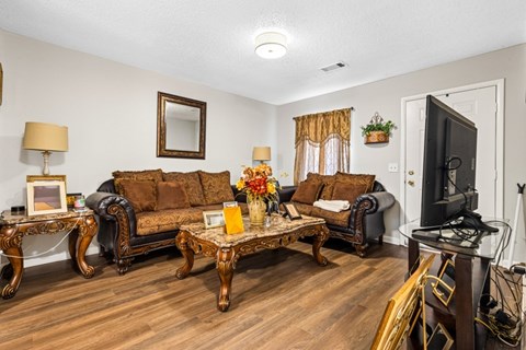 A living room with a brown sofa and a wooden coffee table.