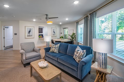 A living room with a blue couch and a grey armchair.