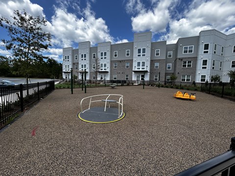 A playground with a yellow circle in the middle of a grey surface.