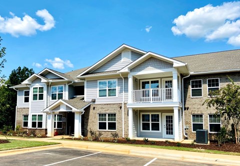 A two-story building with a parking lot in front.