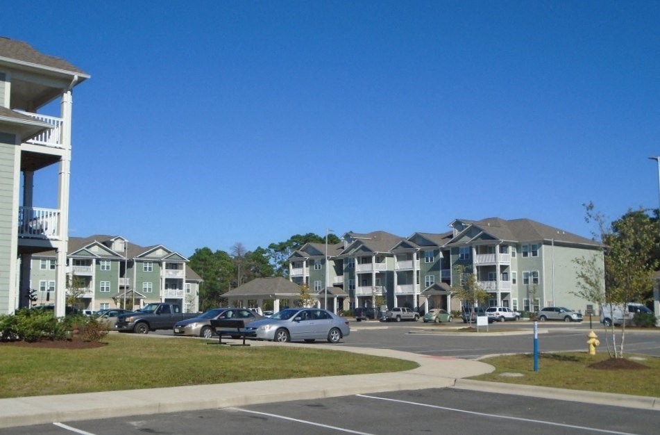 an empty parking lot in front of an apartment building