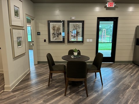 A dining room with a table set for two and a view of a playground outside.
