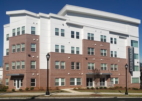 A large brick building with a white section on the top floor.