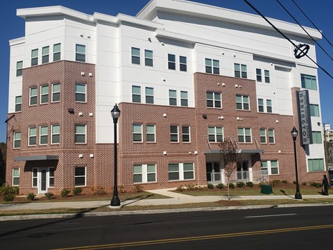 A large white and red building with a street in front.