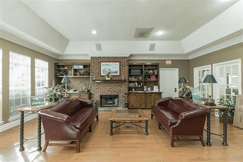 A living room with a fireplace and two brown leather chairs.