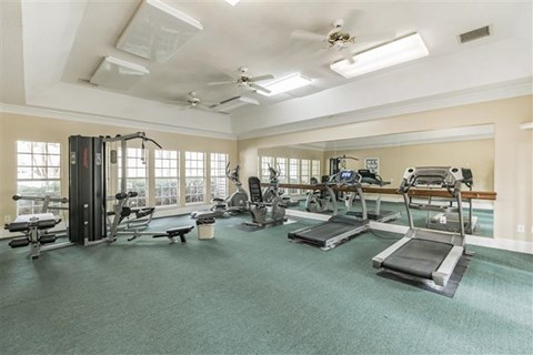 A spacious gym with treadmills, elliptical machines, and other exercise equipment.