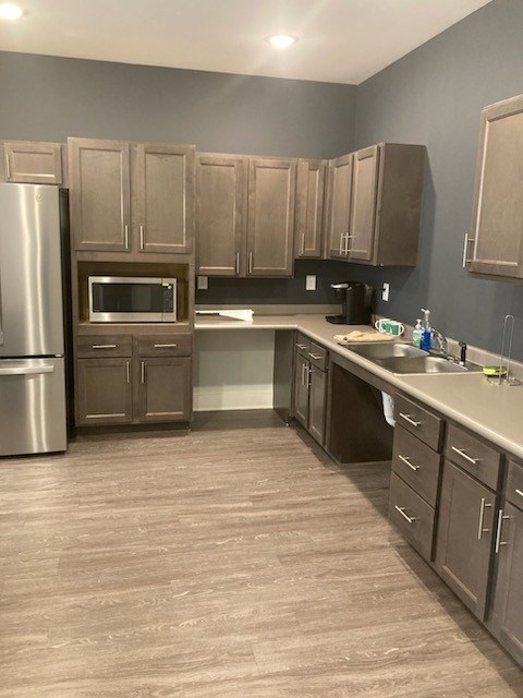 A kitchen with wooden cabinets and a stainless steel refrigerator.