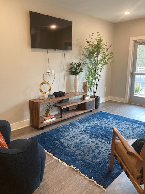 A living room with a blue rug and a wooden chair.