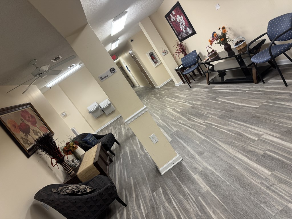 A room with a grey floor and a ceiling fan.