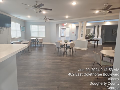 A spacious room with tables and chairs is shown with a timestamp and location information.