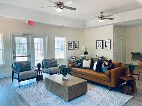 A living room with a brown couch, two chairs, and a coffee table.