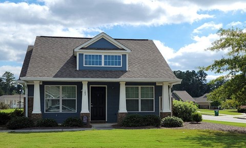 a house with a lawn and a blue door