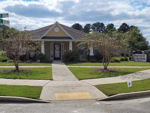 the front of a house with a sidewalk and lawn