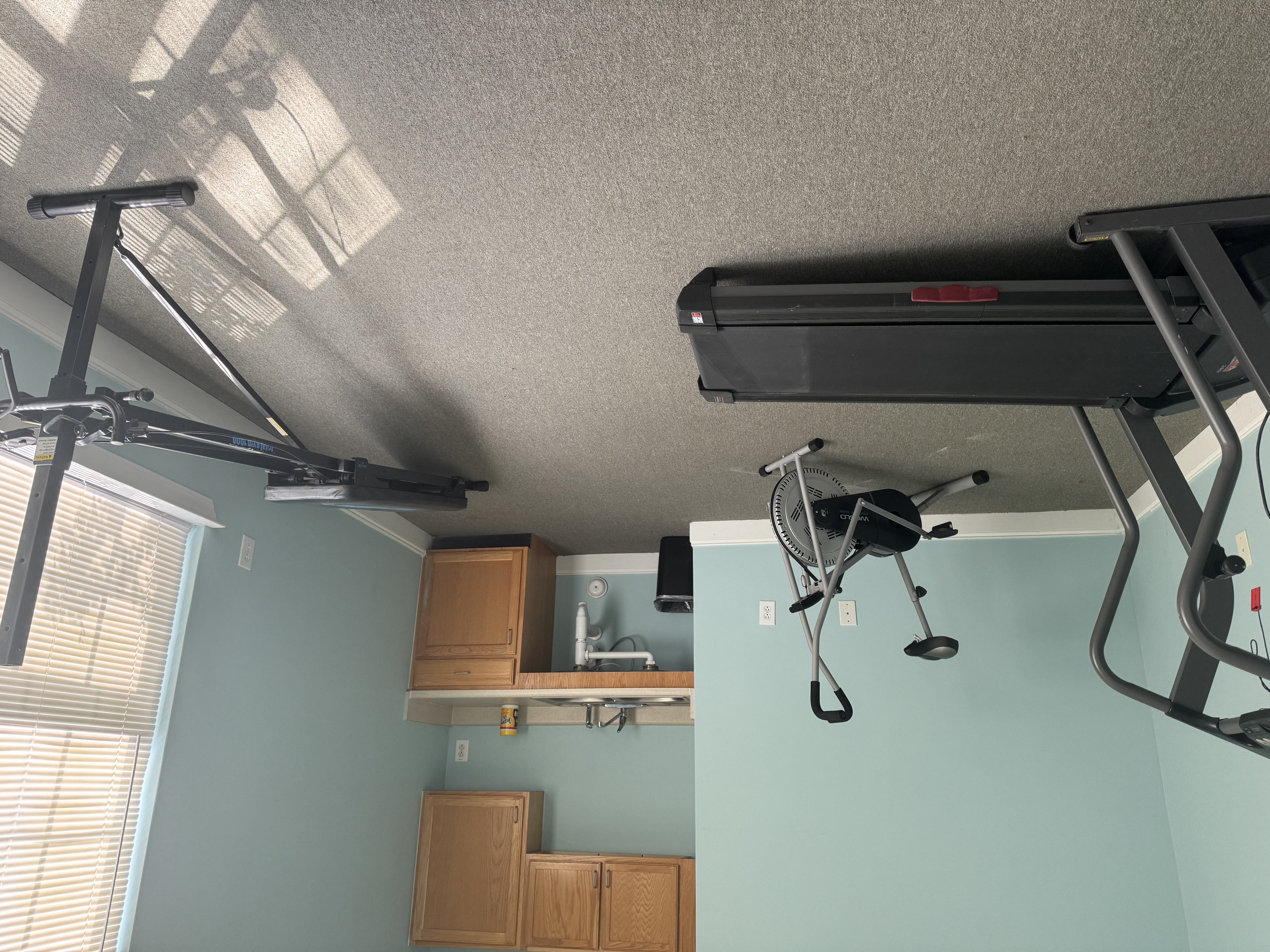 A room with a treadmill and a television.