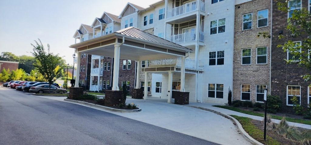 A large white apartment building with a covered walkway entrance.