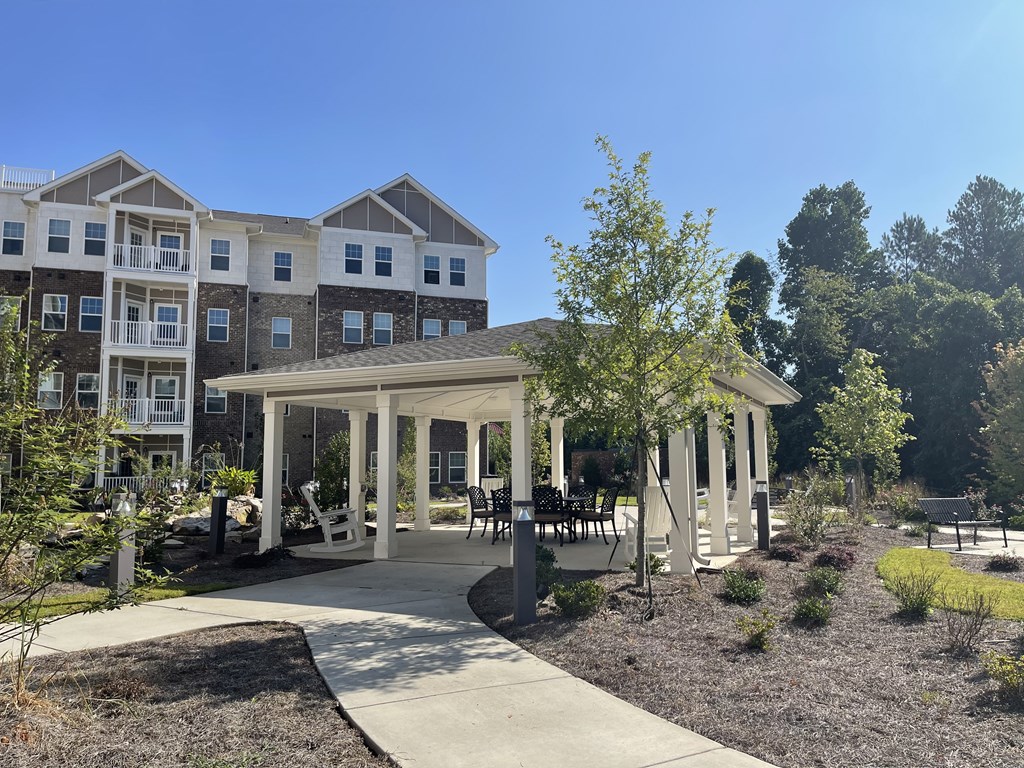 A building with a white canopy and a tree in front of it.